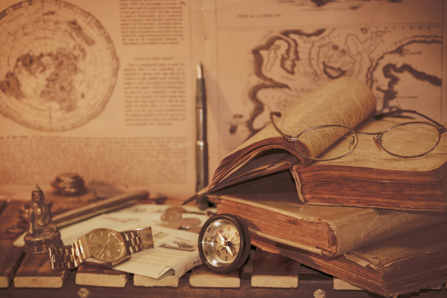 Antike Bücher und Navigationsinstrumente auf einem Holztisch.